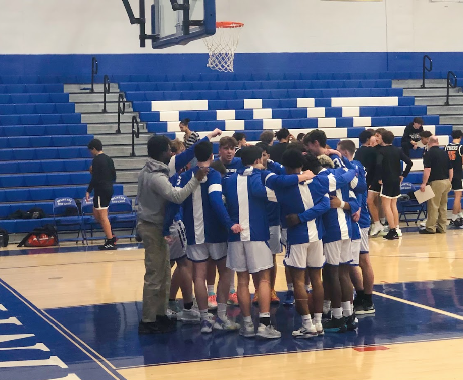 The boys basketball team huddle before the start of the game.