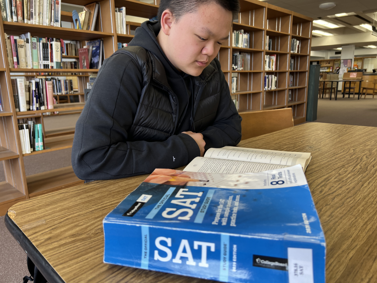 Reporter Evan Ung peruses SAT review materials in the Braintree High Media Center.