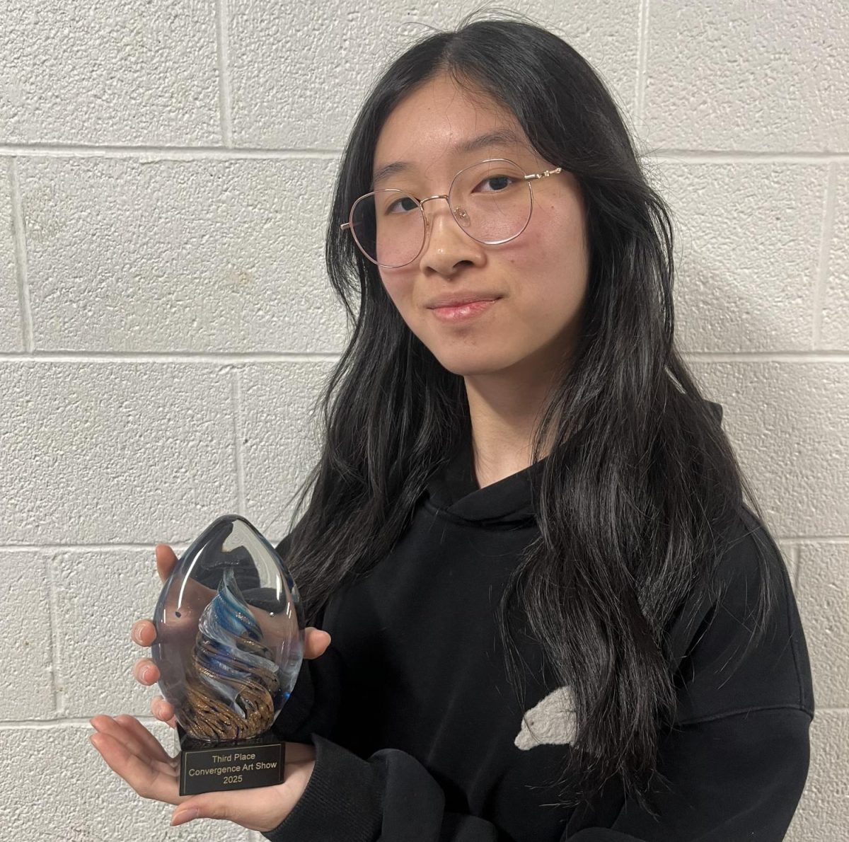 Junior Janice Wu displays her third place trophy from the Convergence Art Show at CATS Academy.