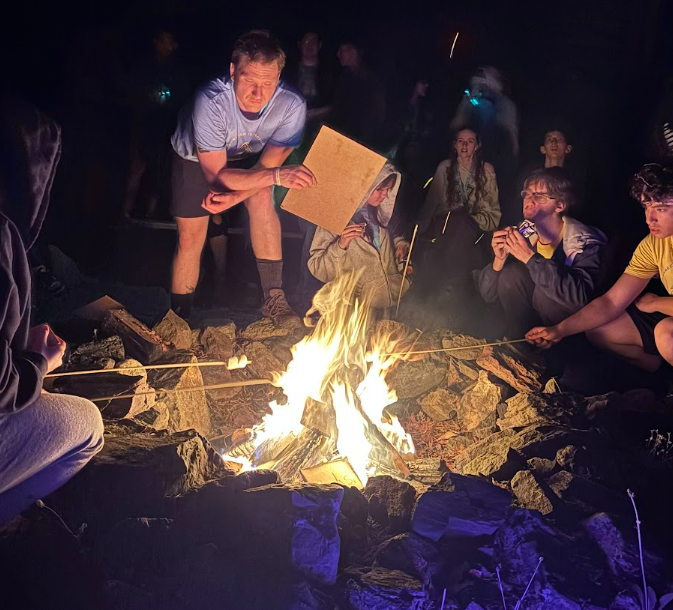A group of campers gathered around the bonfire at RYLA Camp.