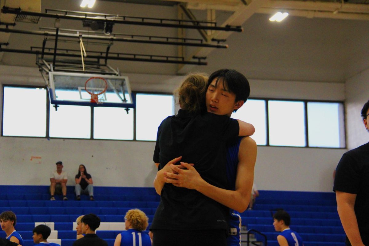 Coach Roberta hugs Senior Justin Liu, #10, after the game is complete. 
