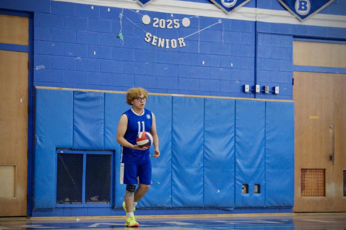 Junior Matty Homez, #11, runs up for a serve. 