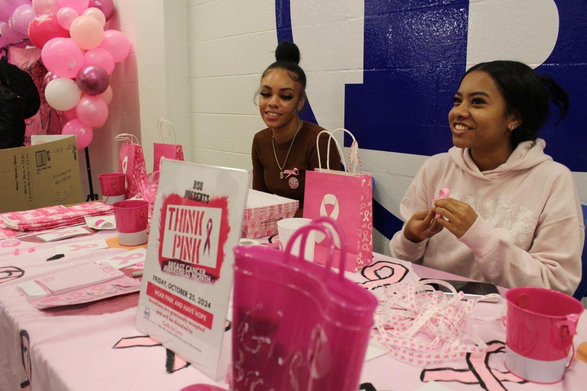 BSU President Moriah Cambronero (right) and Jeyla Monteiro (left) pass out pink ribbons for Think Pink in the Braintree High Cafeteria on Friday, October 24th.