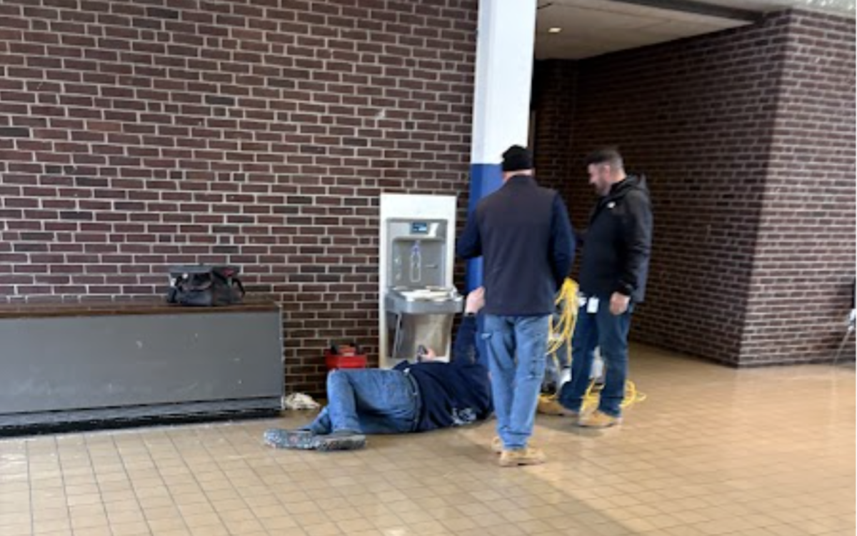 Maintenance men work to repair a water fountain on the first floor of BHS. While this fountain was repaired, others have been removed.